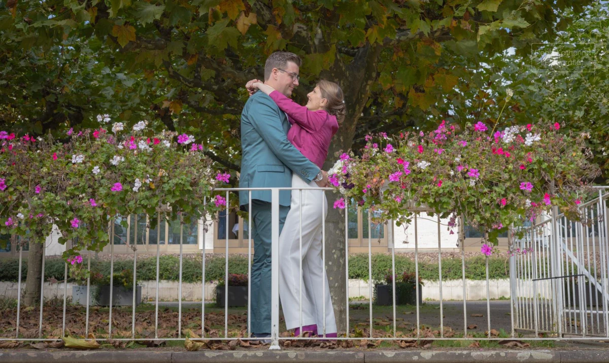 Brautpaar küsst sich vor blühenden Rosen