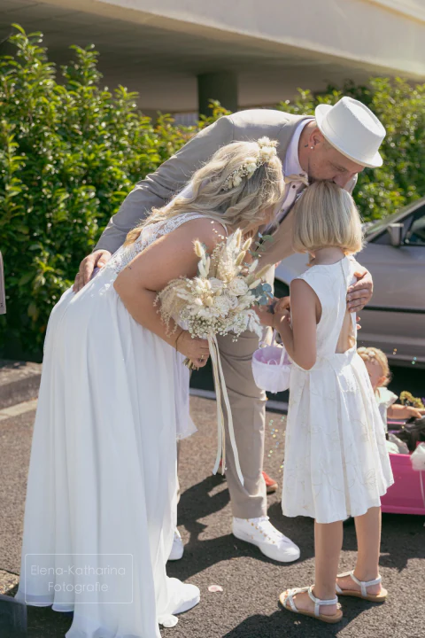 Zärtlicher Moment zwischen Braut und Kind