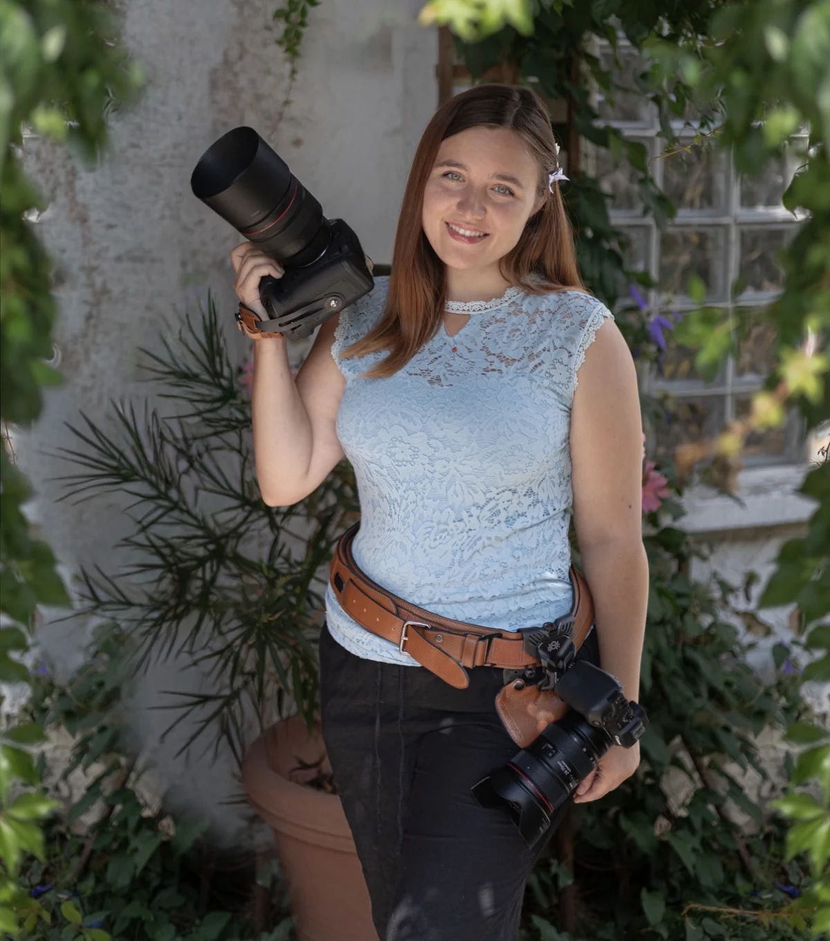 Elena-Katharina mit zwei professionellen Kameras im Grünen