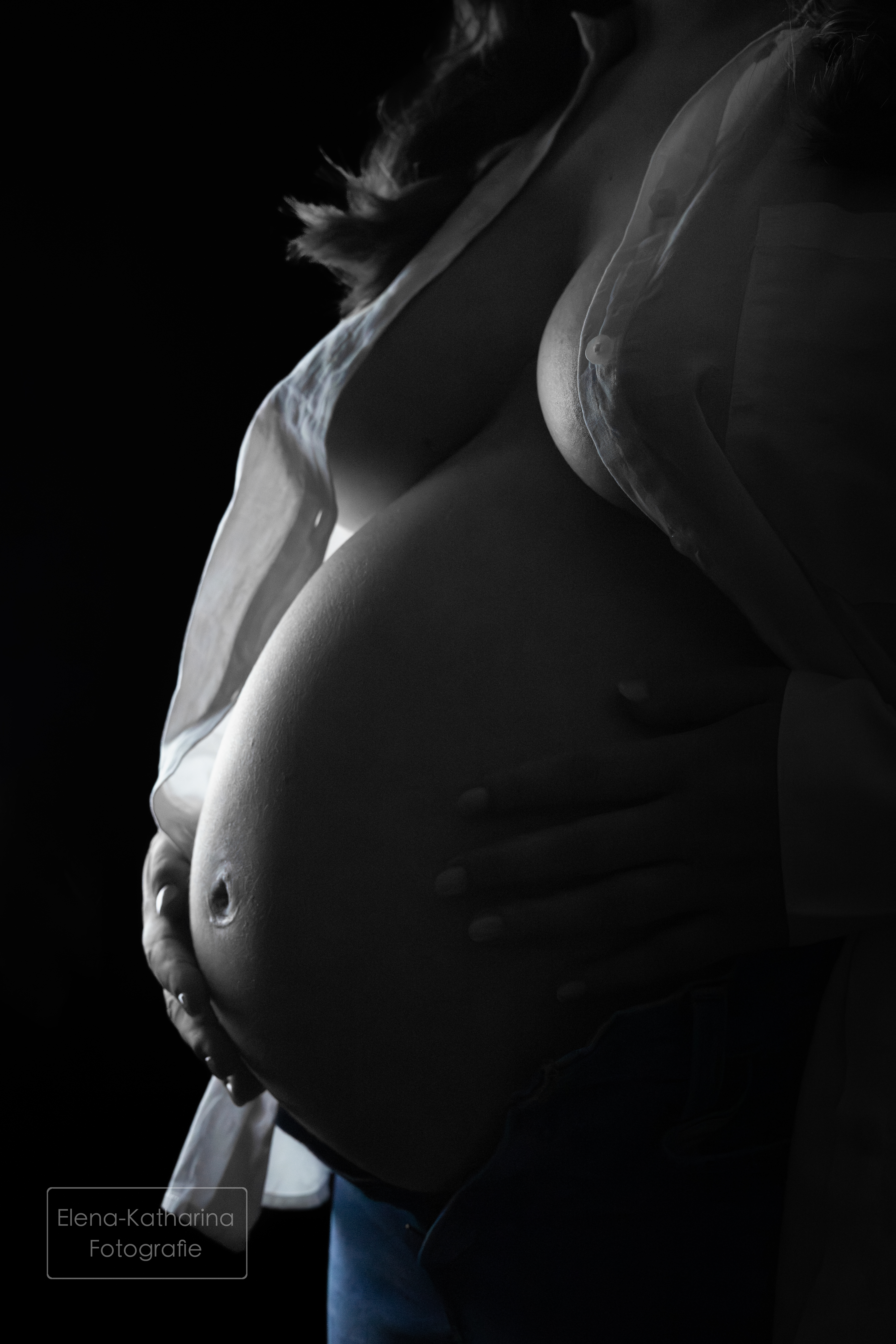 Sanftes Schwangerschaftsportrait im dunklen Licht